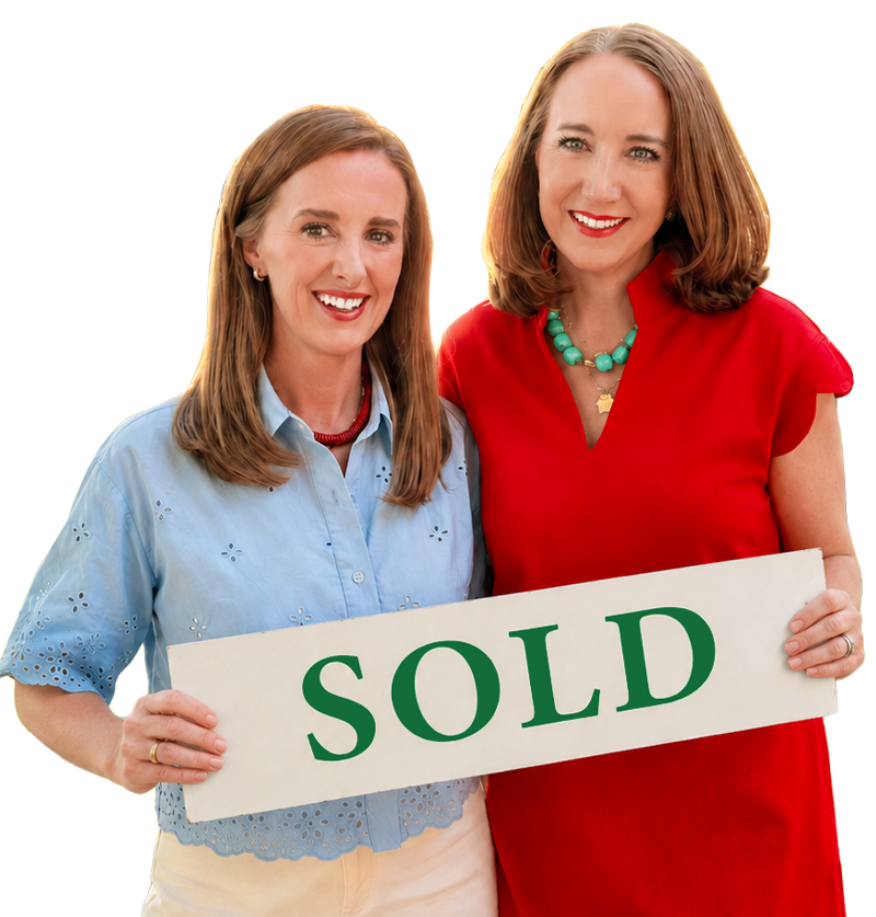 Katie and Callie smiling and holding a white sign saying "SOLD" in green